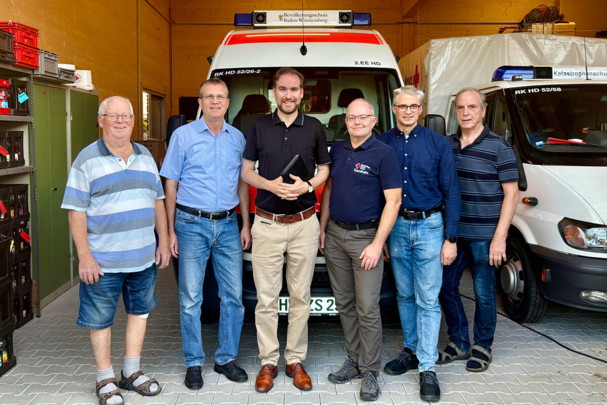 Andreas Sturm mit Vertretern des DRK Eppelheim und Stadtrat Volker Wiegand vor Einsatzfahrzeugen